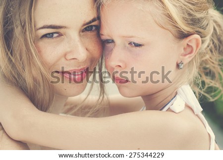 Hugging smiling mother and daughter. Family, child and happiness concept. Toned image