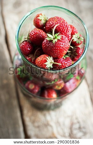 Close up of Organic Strawberry in Green Tin on Wooden Background. Healthy Eating. Bio Lifestyle. Top view
