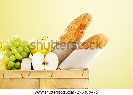 Basket with Food, Bread and Fruit Isolated on Yellow. Fresh Organic Products