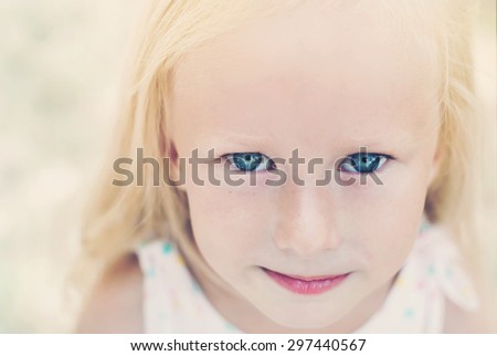 Portrait of Cute Little Girl with Blue Eyes in Summer Day. Toned Image
