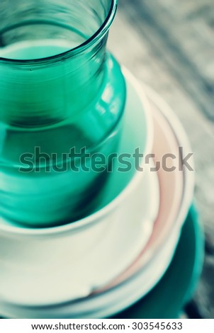 Old Ceramic Plates and Glass Tin on the old wooden background. old tableware. Toned image