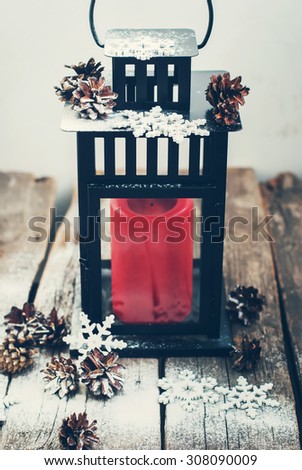 Christmas Lantern with Red Candle and Decorated Snow Flakes on Wooden Table