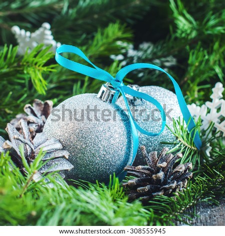Christmas Table Decorated with Two Silver Bright Balls, Snowflakes, Pine Cones and Green Fir Tree