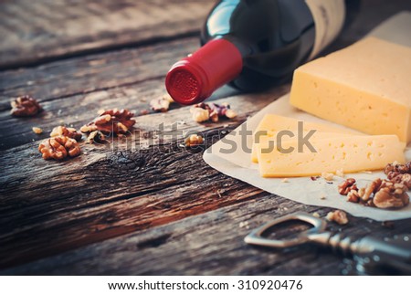 Red Wine, Walnuts and Cheese on Wooden Table. Rural Style