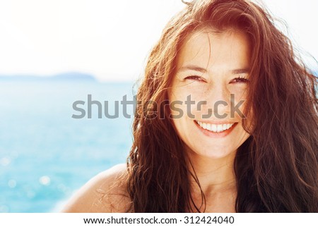 Smiling Suntanned Woman On the Background by Blue Sea in Sunlight. Summer day