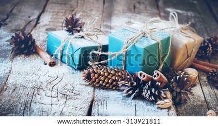 Holiday Blue Boxes with Linen Cord, Cinnamon, Pine cones, Nuts. Natural Gifts on Wooden Background. Toned