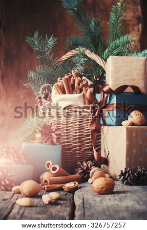 Christmas Natural Gifts with Boxes, Basket, food, Pine Cones, Walnuts on Wooden Background. Toned