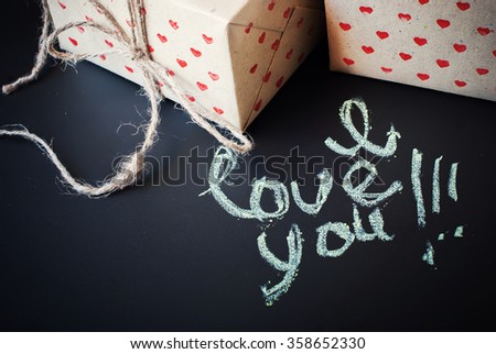 Message I Love You and Boxes in Hand made Paper with Hearts Pattern on Dark Background