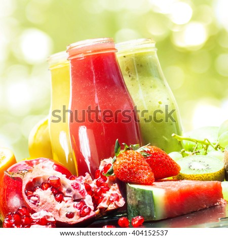 Fresh Juices Smoothie Glass Bottles Red Yellow Green Fruits Vitamins Healthy Concept isolated on Summer Light Boke Background