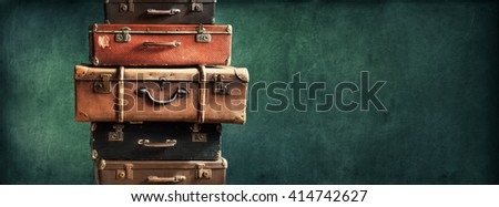 Vintage Pile Ancient Suitcases Form of Tower Design Concept Travel Luggage Traveler on Shabby Black Background Long Format