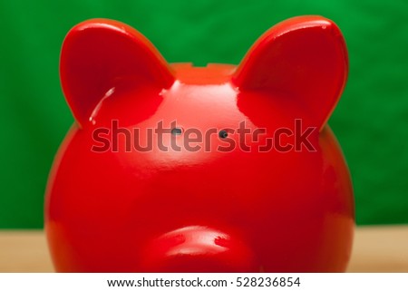 Red pig bank on green background.