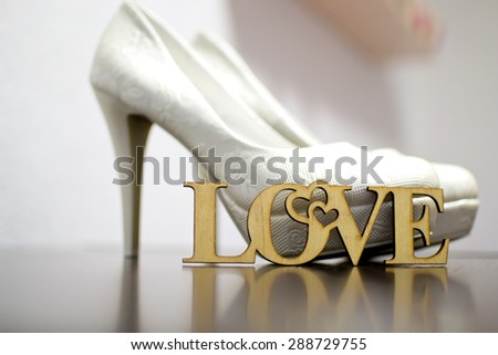 wedding shoes next to the wooden inscription, love