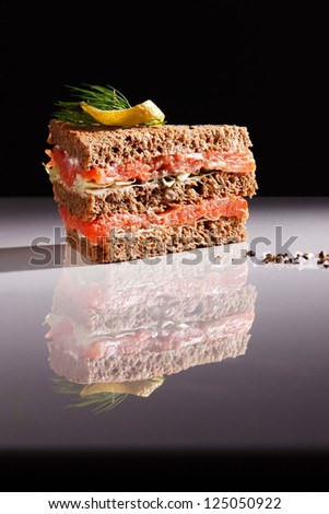 A tuna smoked salmon sandwich garnished with dill and lemon, is a healthy option