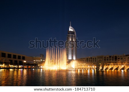 DUBAI, UAE - MAR 24: The Dancing Fountain of Dubai performs to the beat of the selected music at dusk on Mar 24, 2014 in Dubai, UAE. The fountain is overlooked by Dubai Mall and the Address Hotels