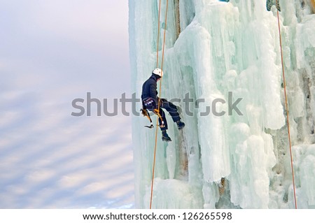 Man climbing an ice cliff