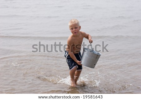 Blonde boy carrying a bucket of water