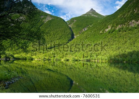Lush green mountain reflecting in a lake