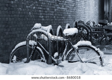 Night shot of a bike under a thick layer of snow