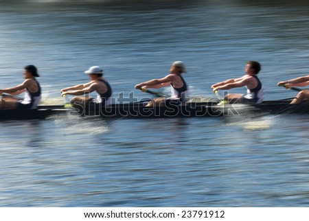 Rowers in a rowing boat pulling in harmony, motion blurred to accent speed