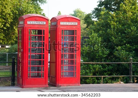 Two phone booths standing out against the green natural background