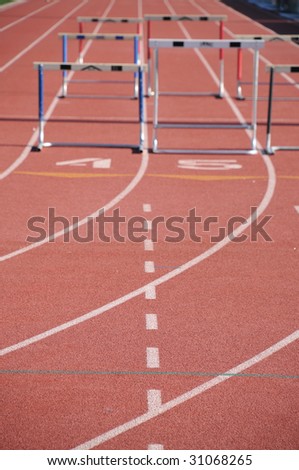 hurdles on a runners track with running lanes