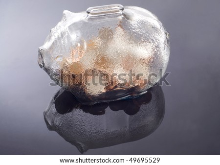 a glass piggy bank with coins  feflecting on a water base background
