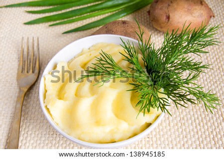 mashed potatoes with dill over straw background lose up horizontal