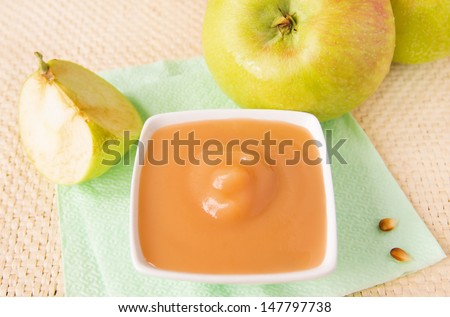 Fresh homemade applesauce (apple puree, babyfood) with green apples and seeds close up, horizontal, vegetarian