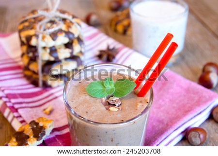 Milkshake (chocolate smoothie) in glass with mint, nuts and homemade cookies, breakfast horizontal close up