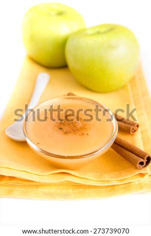 Fresh homemade applesauce (apple puree, babyfood) with cinnamon, spoon and apples on napkin close up, vertical