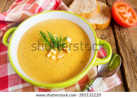 Lentil cream soup with cheese and dill  on napkin and wooden background, horizontal close up