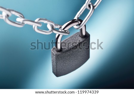 Close-up view of a closed chain with a padlock on blue background
