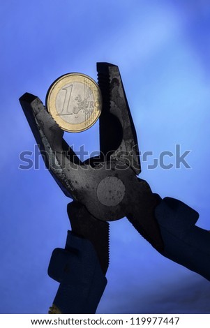 Euro coin and pliers symbolizing the European Union economic depression and the European currency under pressure