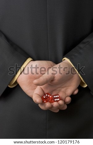 Business man holding a pair of dice behind his back preparing for the chance of a lifetime