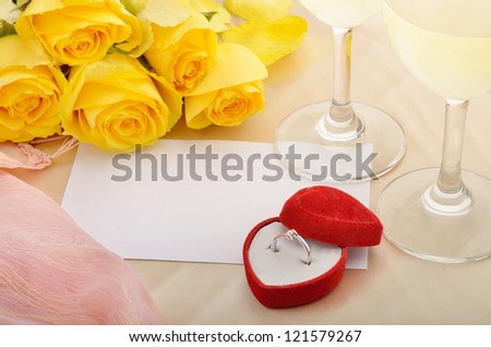 Blank sheet of paper for Valentine message with yellow roses, wine and engagement ring