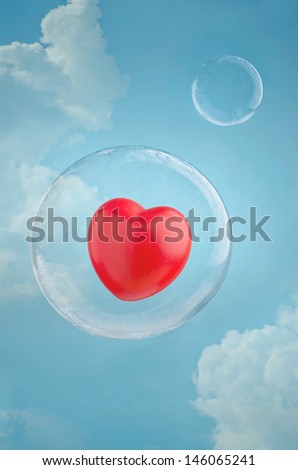 Love is in the air. Red heart floating in a soap bubble in the sky