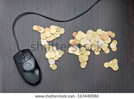 Office desk with world map made of money coins and computer mouse