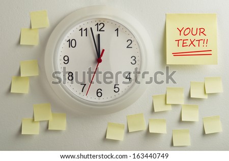 Giant adhesive note on office wall beside a clock