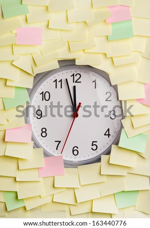 Clock surrounded by blank sticky notes
