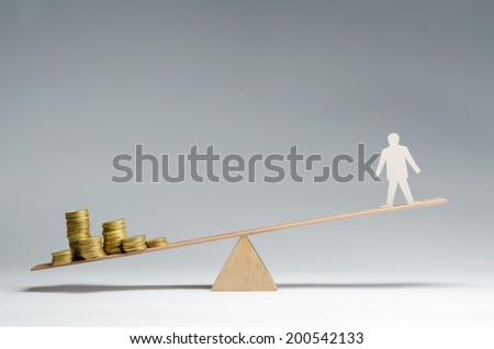 Man balanced on seesaw over a stack of coins