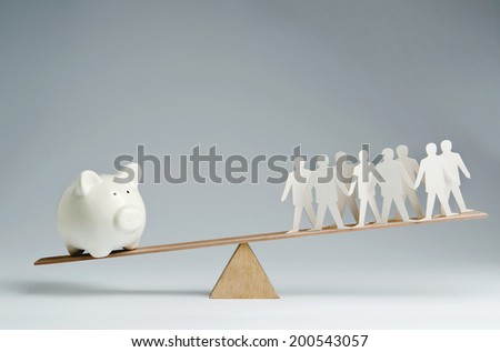 Men balanced on seesaw over a piggy bank