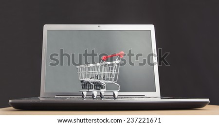 Shopping trolley sitting on open laptop