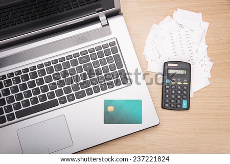 Home finance scene with calculator, laptop and bills