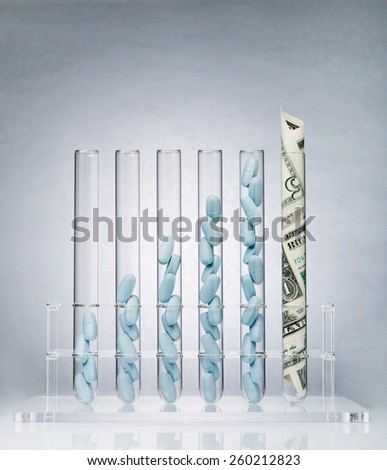 Rolled up US paper banknote in a test tube rack representing the costs of medical research
