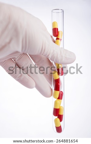 Pharmaceutical research. Hand holding test tube with medicine pills
