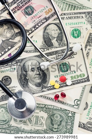 Health care costs. Hundred dollar bills with pills and a stethoscope