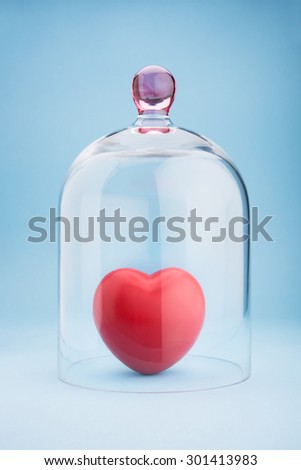 Red heart protected under a glass dome on blue background