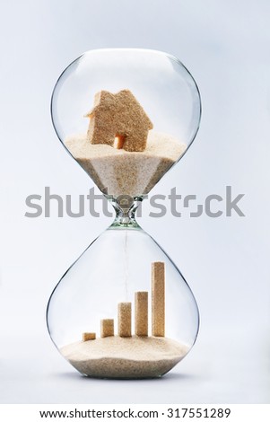 Real estate concept. Business growth graphic bar made out of falling sand from house flowing through hourglass