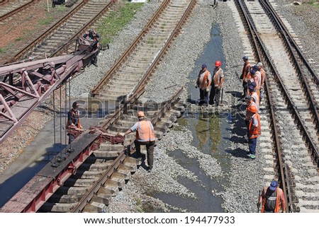 KIEV, UKRAINE - MAY 22, 2014: Renovation of the railway. Workers change the old site to the new railway