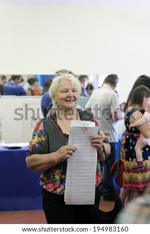 Kiev, Ukraine - May 25, 2014: Election of the President of Ukraine and Kiev measure. woman received byuletni for voting.